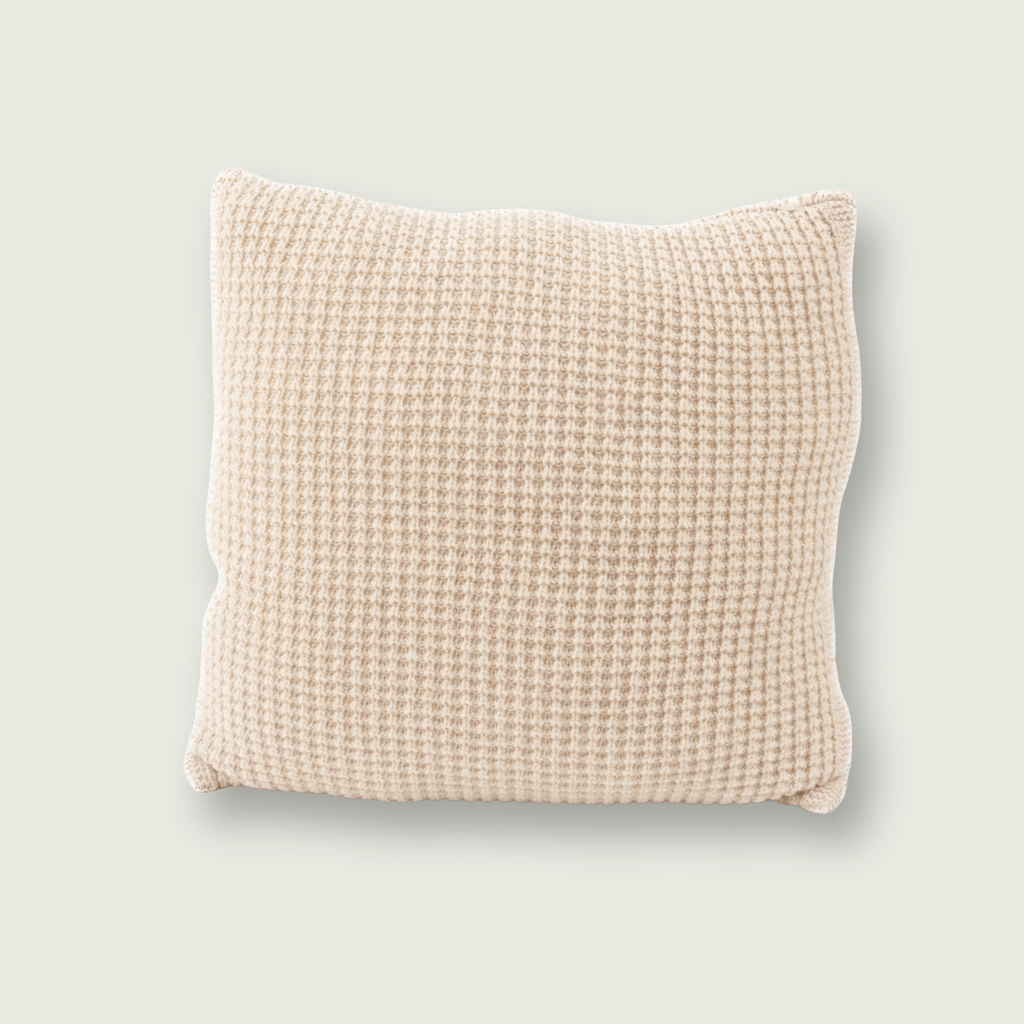 Beige merinowollen sierkussen met wafelpatroon 50 x 50 cm, op neutrale achtergrond. 