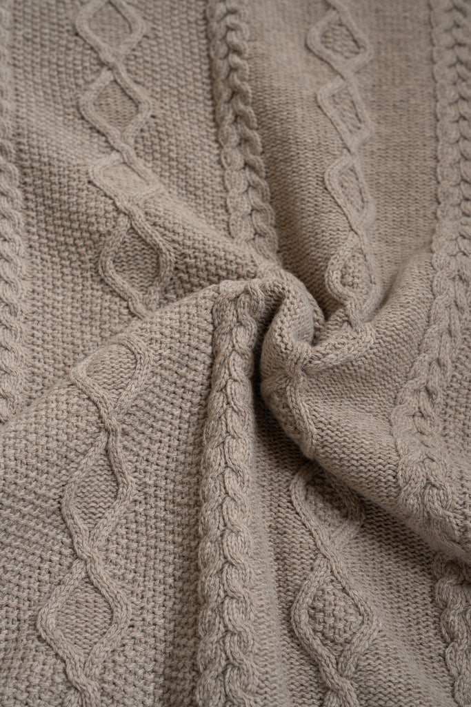 Bruine plaid van 100% merinowol, 130 x 170 cm, vlechtmotief, gefotografeerd als close-up van textuur en kleur.