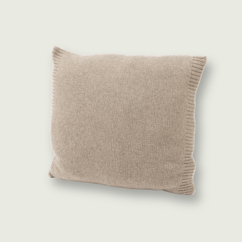 Gladgebreid bruin sierkussen van 100% merinowol, 50 x 50 cm, gefotografeerd op neutrale achtergrond.