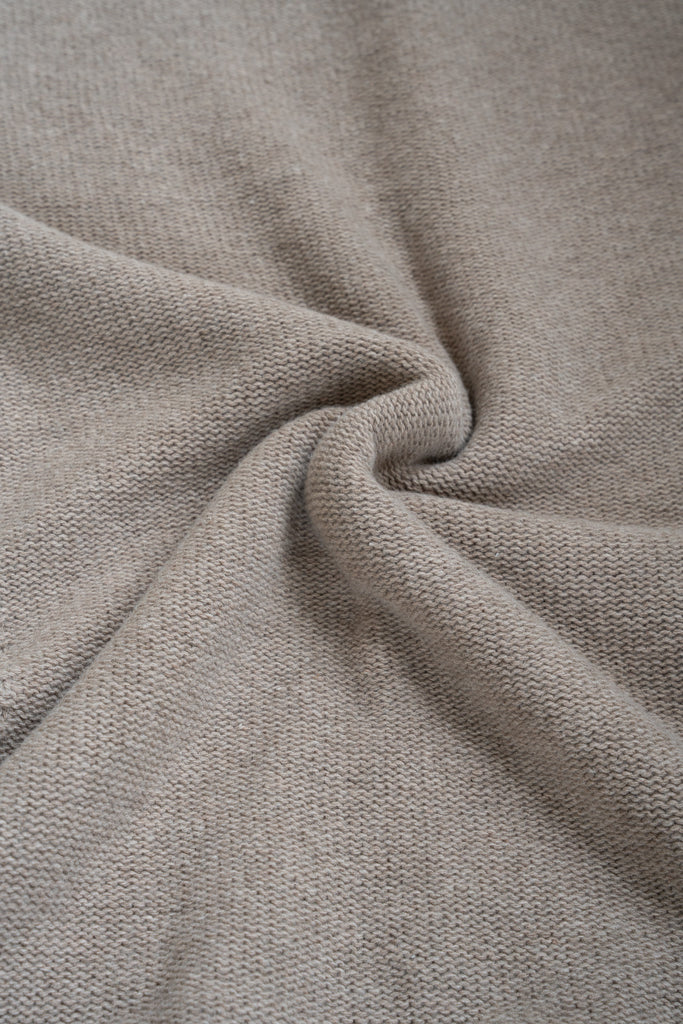 Bruine plaid van 100% merinowol, 130 x 170 cm, glad gebreid, gefotografeerd als close-up van textuur en kleur.