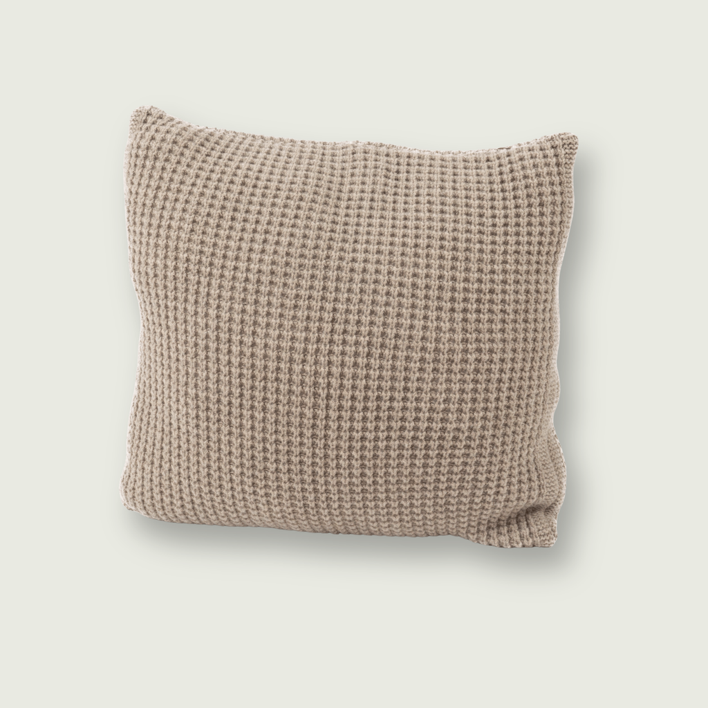 Bruin sierkussen van 100% merinowol met wafelpatroon, 50 x 50 cm, gefotografeerd op neutrale achtergrond.