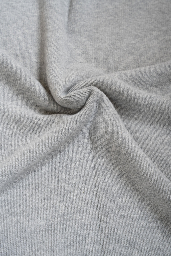 Grijze plaid van 100% merinowol, 130 x 170 cm, glad gebreid, gefotografeerd als close-up van textuur en kleur.