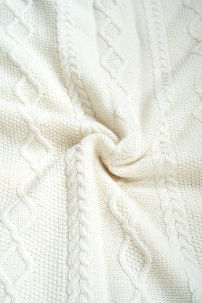 Witte plaid van 100% merinowol, 130 x 170 cm, vlechtmotief, gefotografeerd als close-up van textuur en kleur.