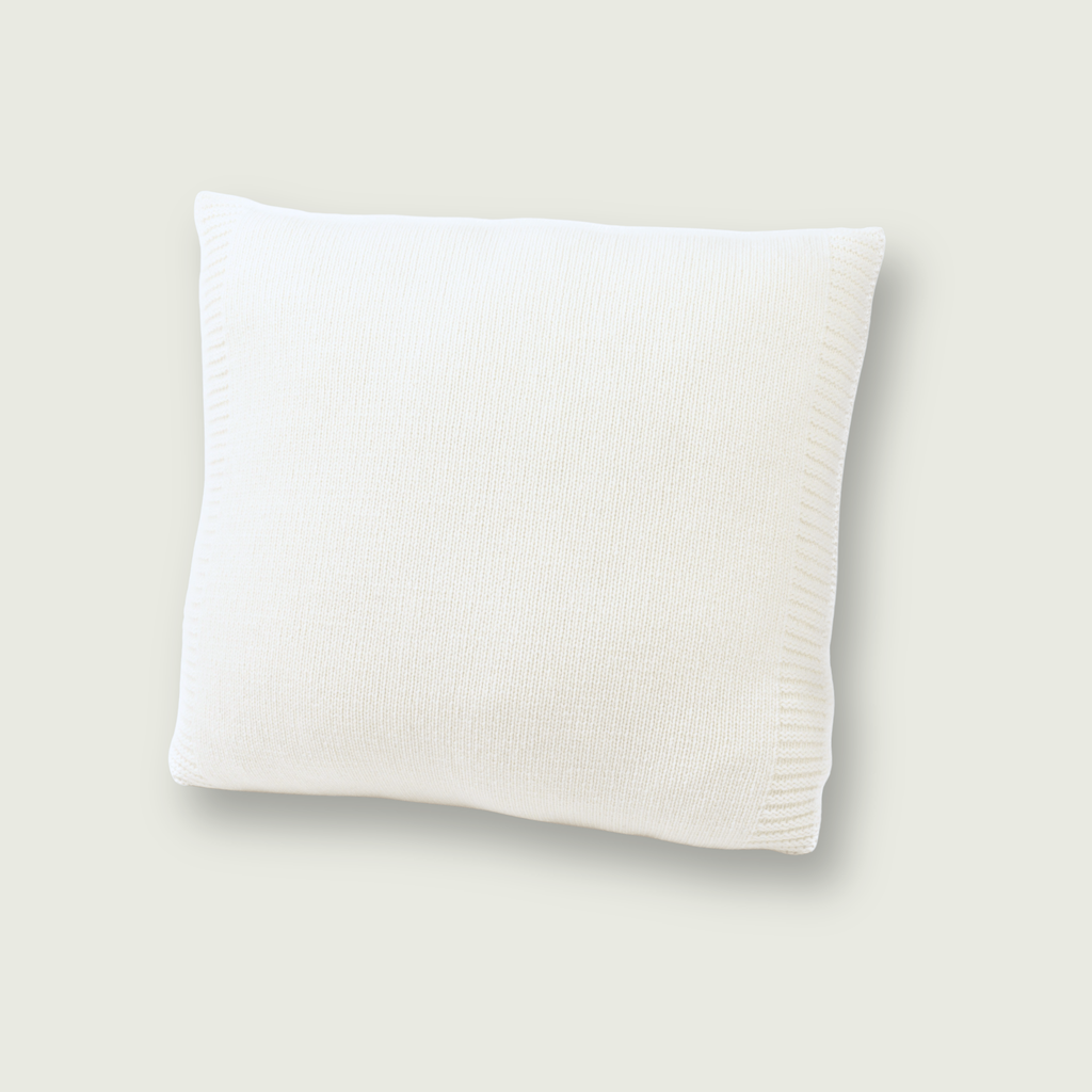 Gladgebreid wit sierkussen van 100% merinowol, 50 x 50 cm, gefotografeerd op neutrale achtergrond.